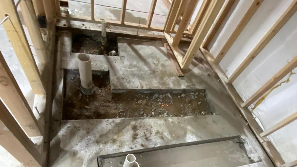 Basement Bathroom Rough-In New basement bathroom framing with plumbing rough-in lines run through open stud walls