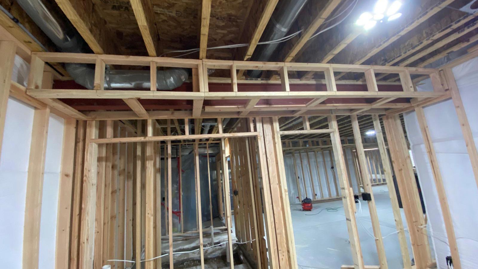 Basement Framing & HVAC Soffit Basement wall framing in progress with a framed soffit boxing in the HVAC ductwork overhead