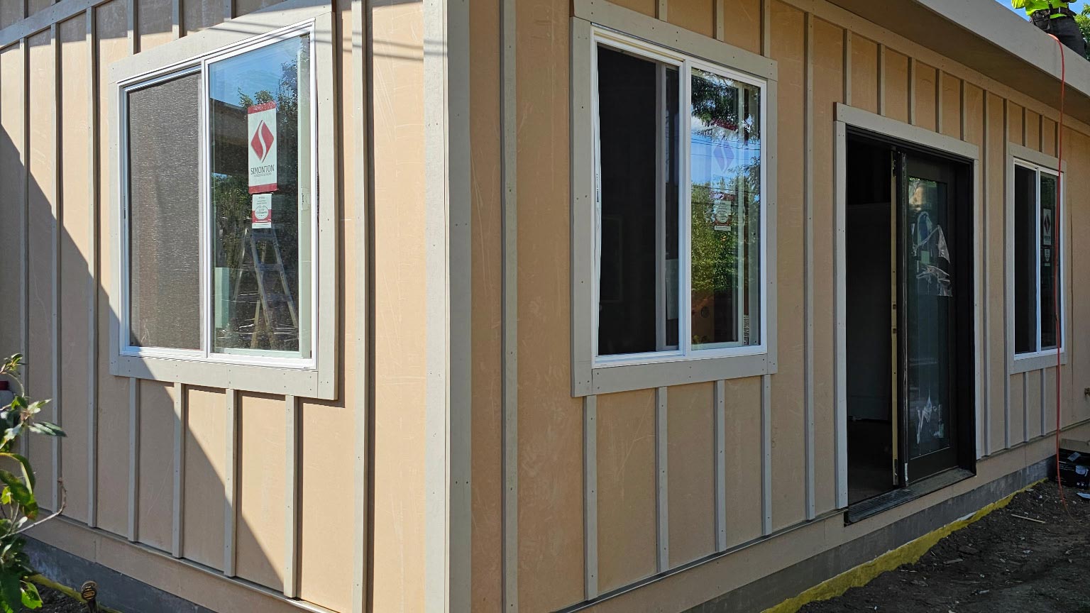 Board-and-Batten Addition Modern home addition with tan board-and-batten siding and a low-slope flat roofline