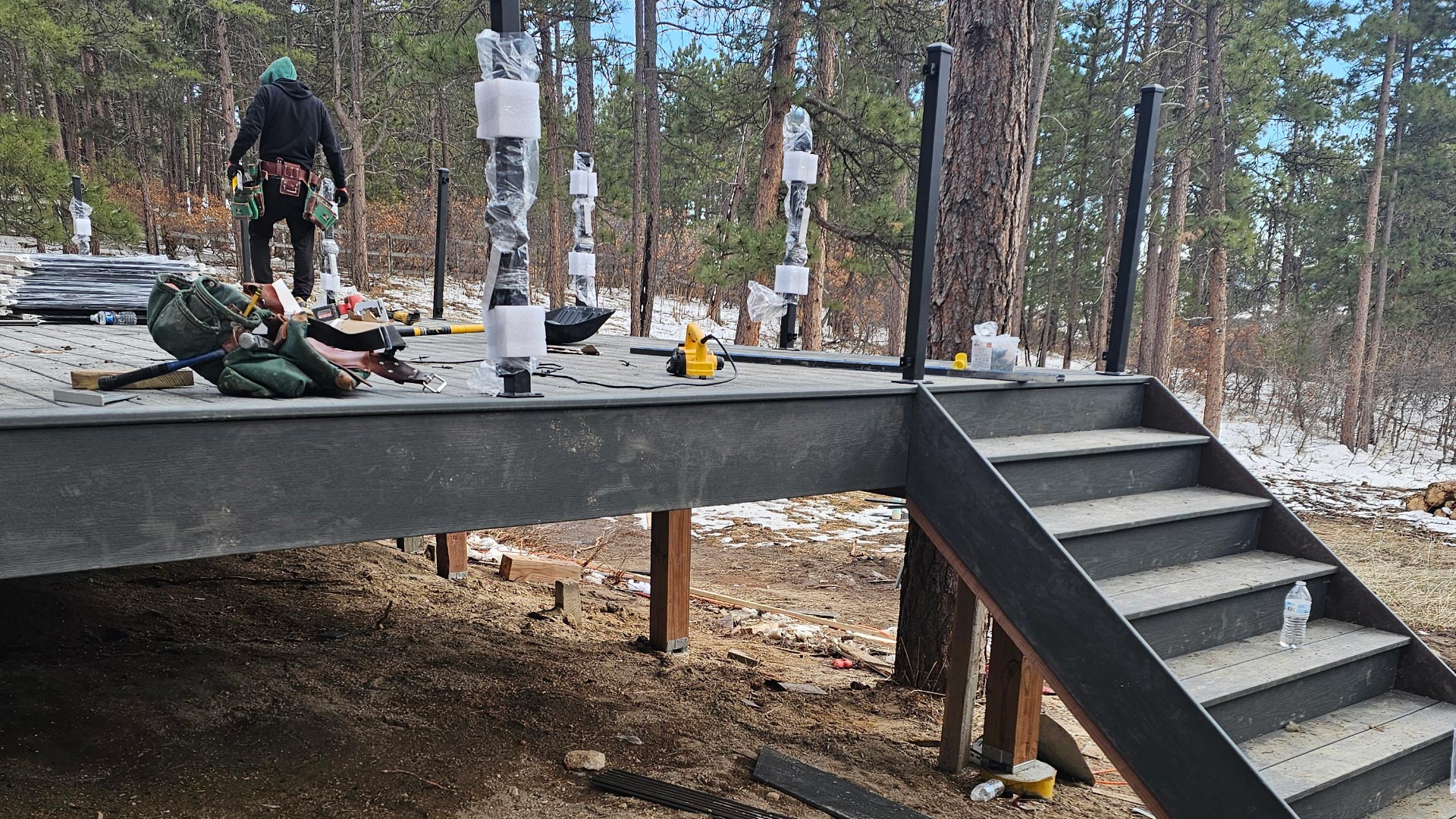 Deck Framing in Progress Deck framing under construction with joists exposed and composite stair treads being installed