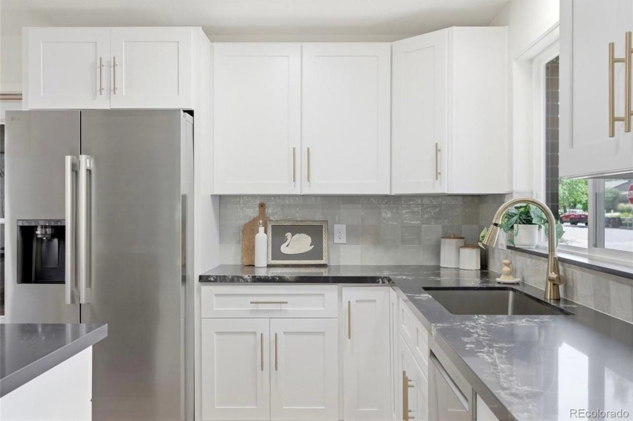 White Shaker Kitchen, Gold Faucet White shaker kitchen with gray tile backsplash, quartz counters and a brushed gold faucet